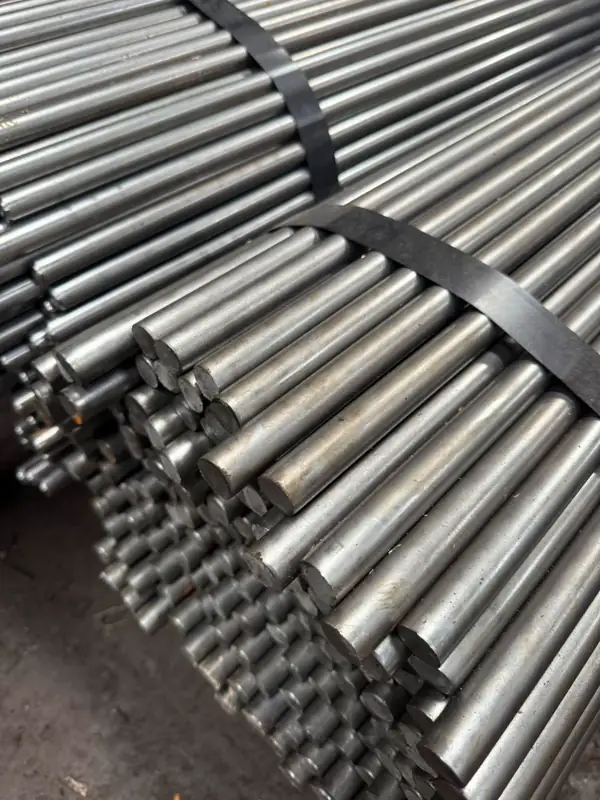 Close-up of a strapped bundle of cold-drawn bright round bars showing sheared ends and polished surface finish